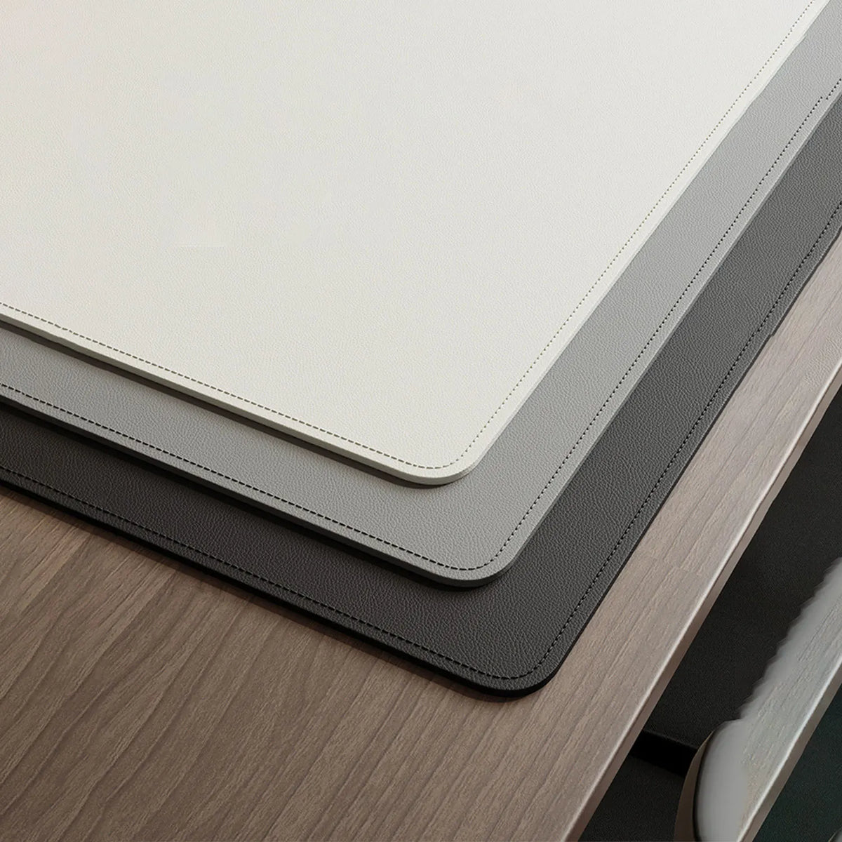 Non-slip leather desk blotter with stitched edges on a wooden desk