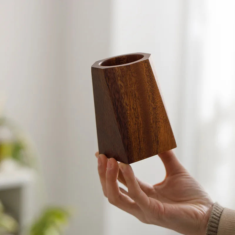 Solid walnut storage cube holding pens on a desk