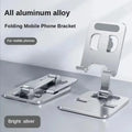 Foldable aluminum phone stand holding a phone upright on a desk