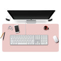 Large stitched vegan leather desk pad under a keyboard and mouse