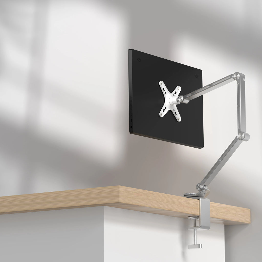 Long arm monitor and tablet mount clamped to a desk edge
