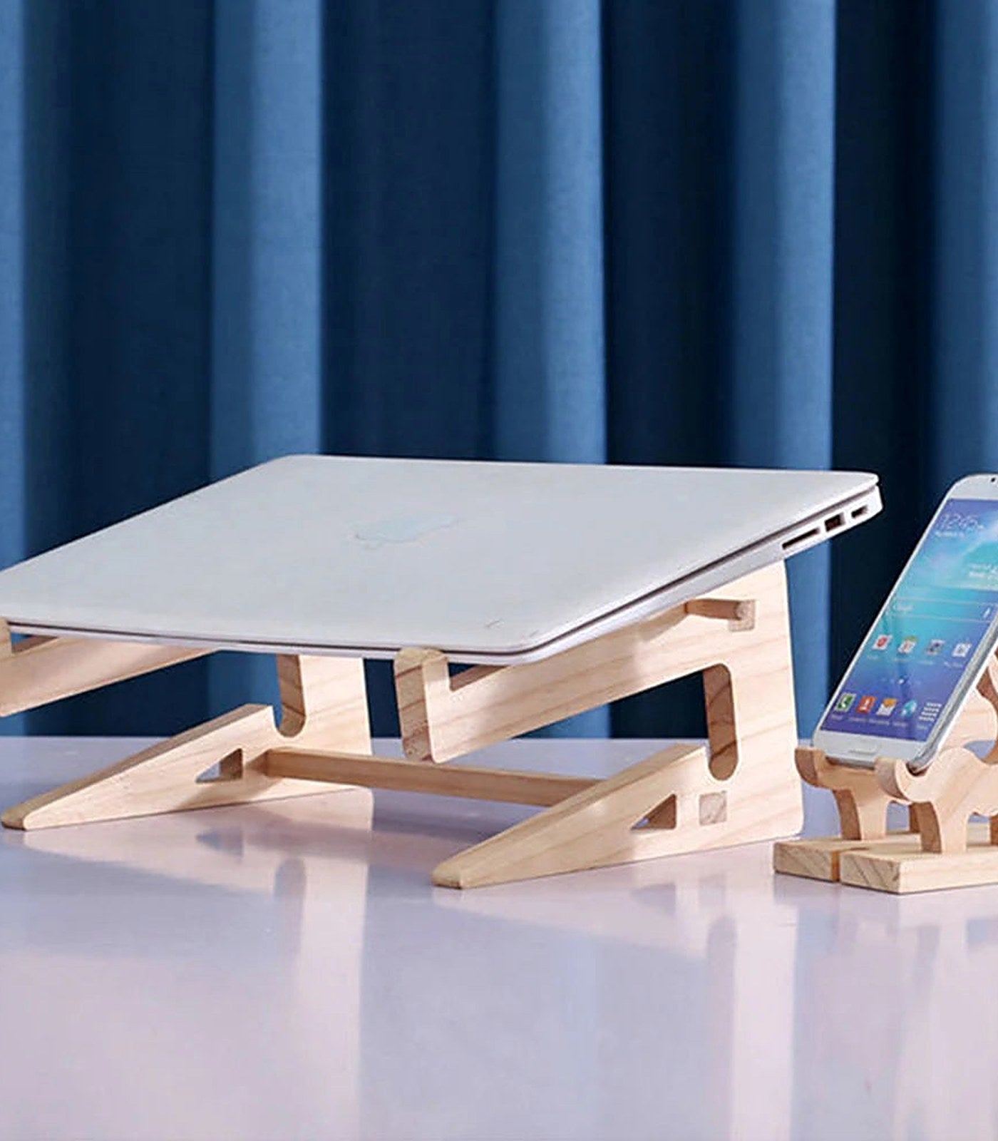 A laptop raised on a solid wood laptop riser